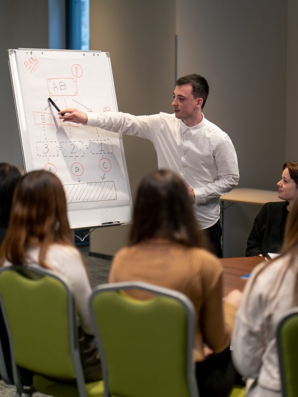 business conference or meeting in a hotel a man on a flipchart shows a development plan for company