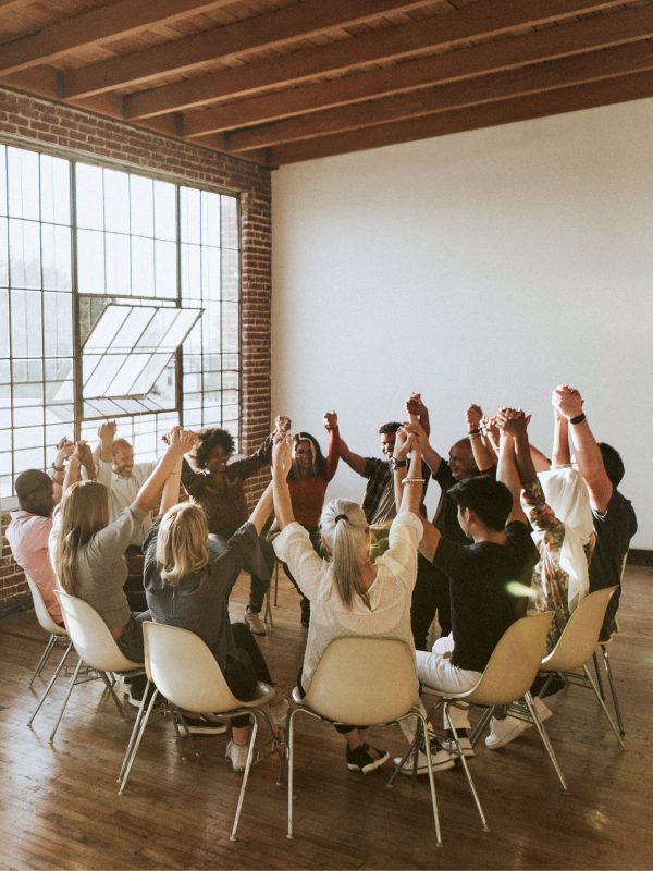 Group of diverse people holding hands up in the air