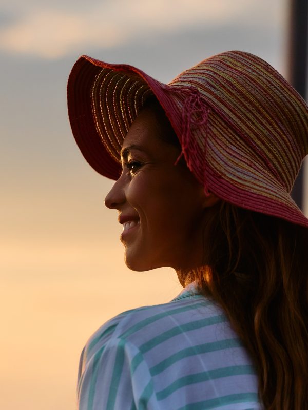 Young happy woman enjoying in sunset on summer vacation. Copy space.