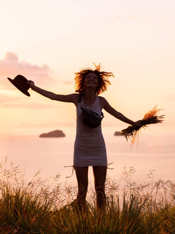 Romantic portrait of calm pretty woman in tropical park with wild pink flowers